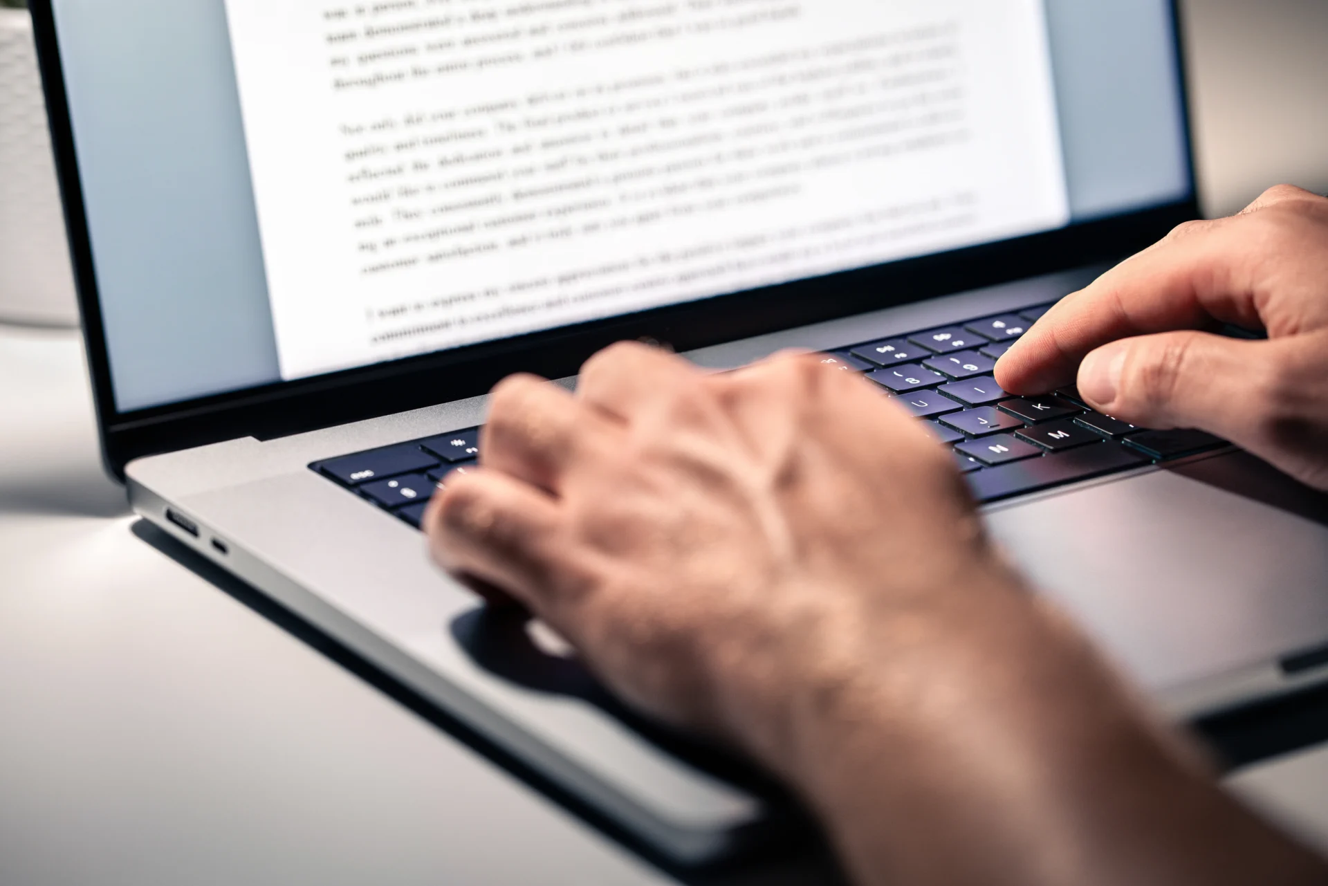 Person typing on a laptop keyboard.