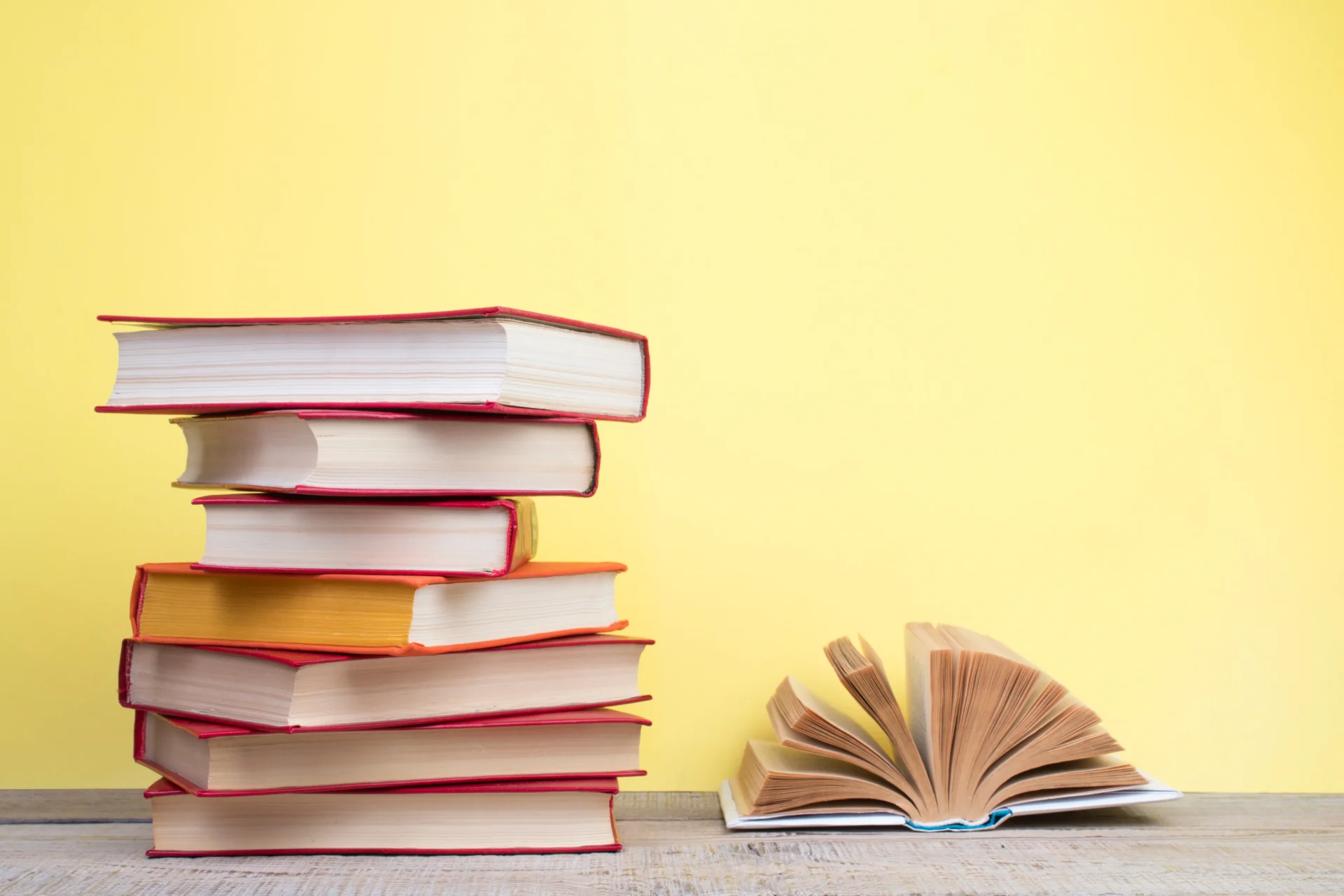 A stack of books and one open book.