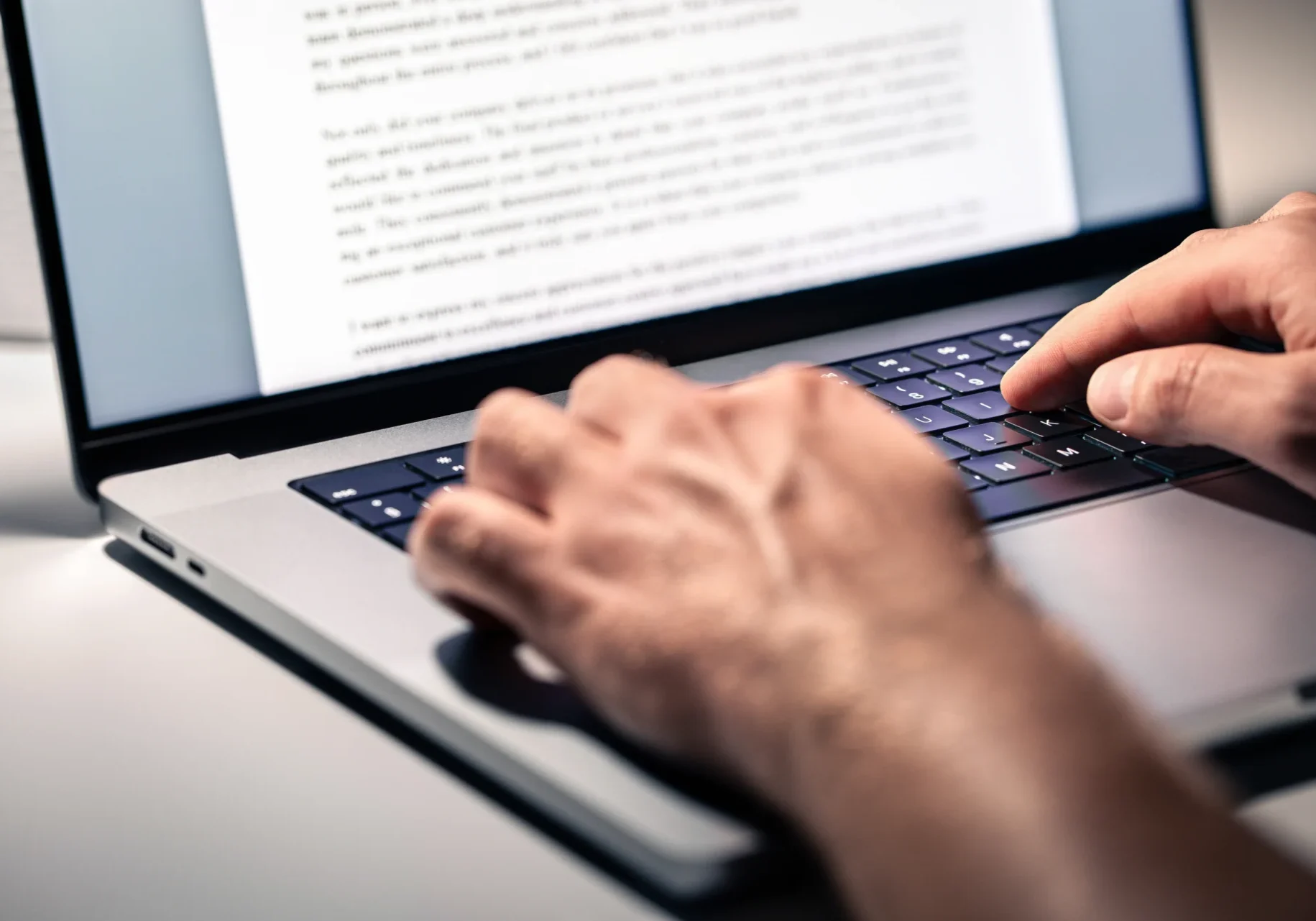 Person typing on a laptop keyboard.