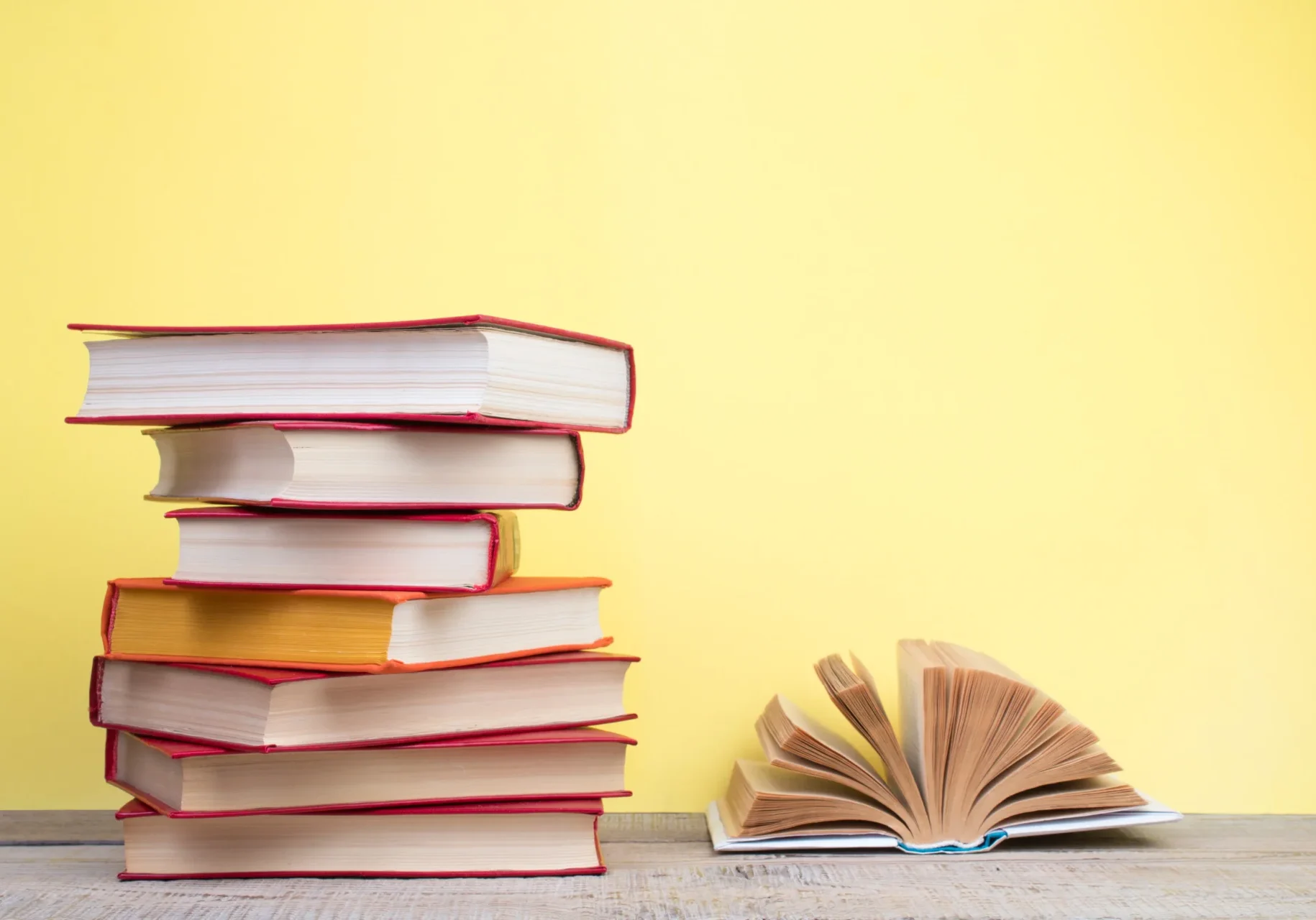 A stack of books and one open book.